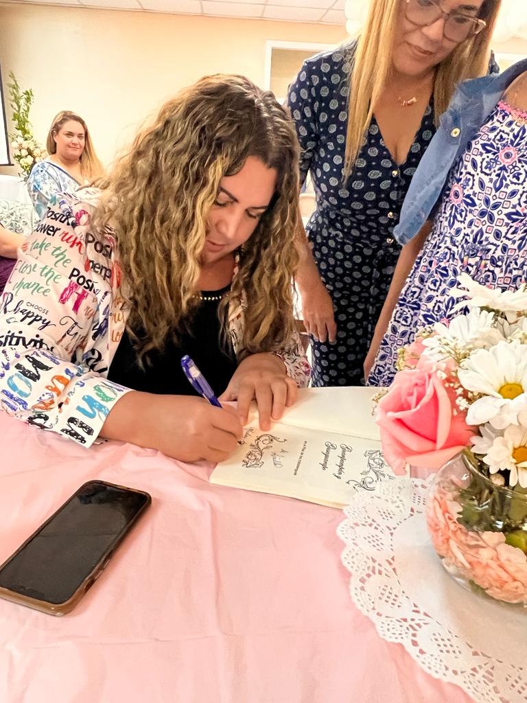 Ariella signing a book